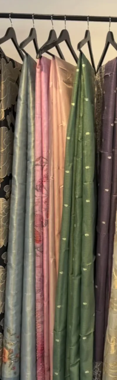 Pastel sarees in mist blue, blush and green on black hangers
